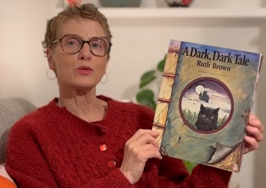 Katie holding A Dark Dark Tale by Ruth Brown
